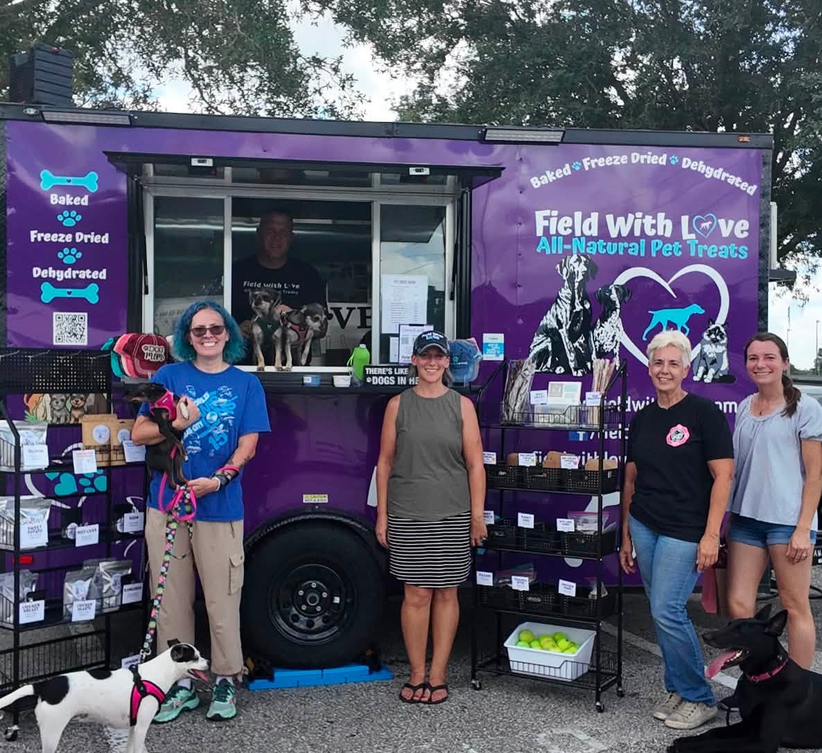 The Field With Love pet treat trailer with its crew, shoppers and their dogs